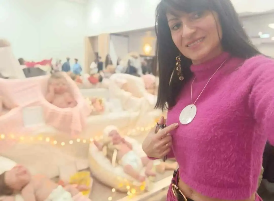 Nathalie Moiselet devant une exposition de ses modèles de bébé Reborn silicone.
